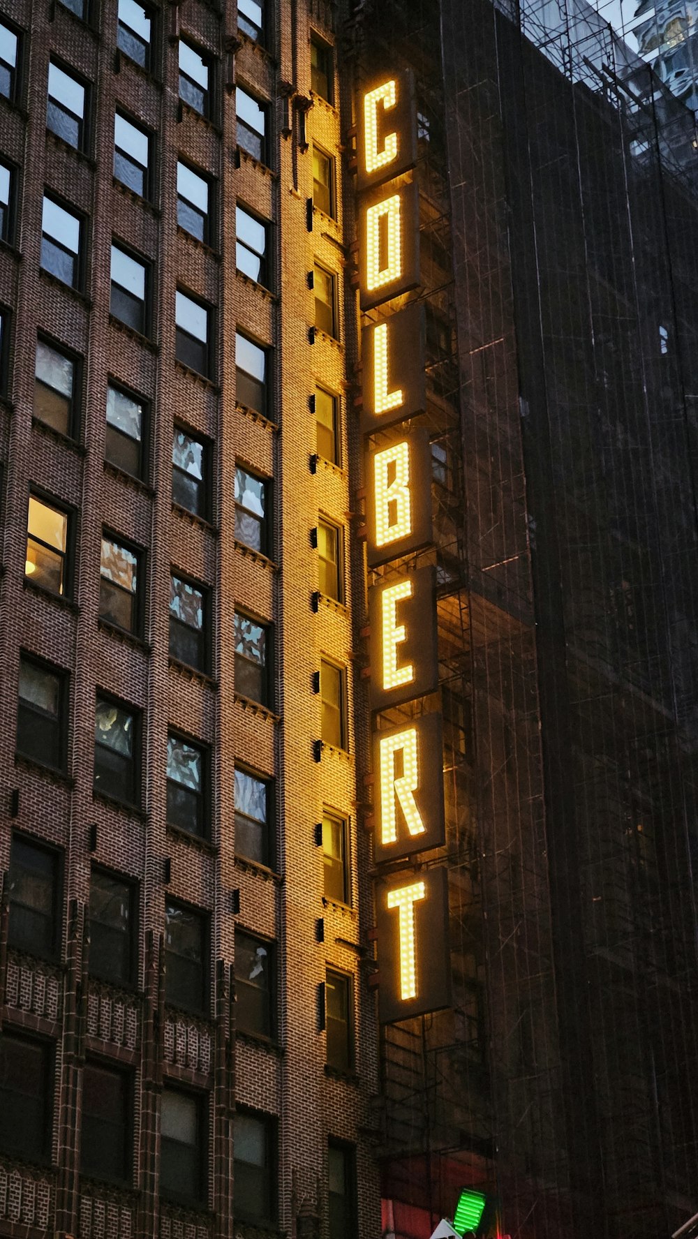 a tall building with a neon sign on the side of it
