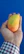 Close-up of a hand holding vibrant raw mango slices with a rustic wooden background.