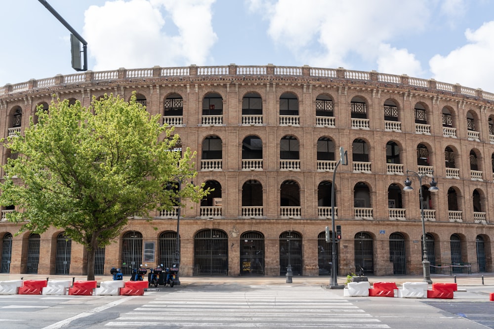 un gran edificio de ladrillo con un árbol frente a él