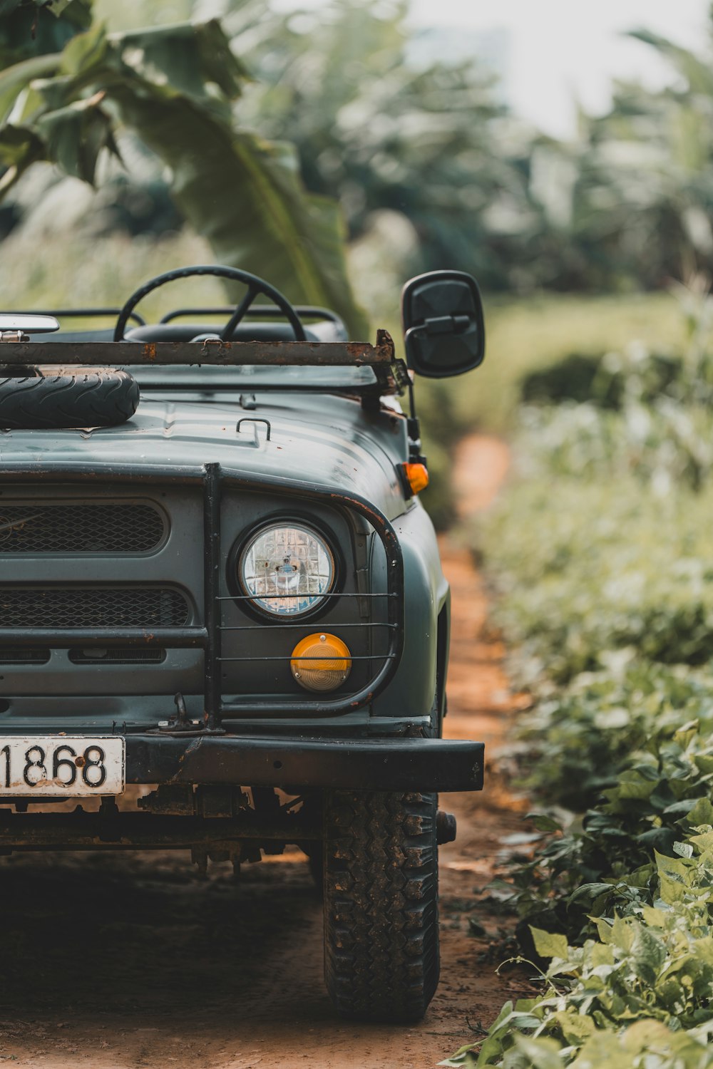 a green truck parked on a dirt road