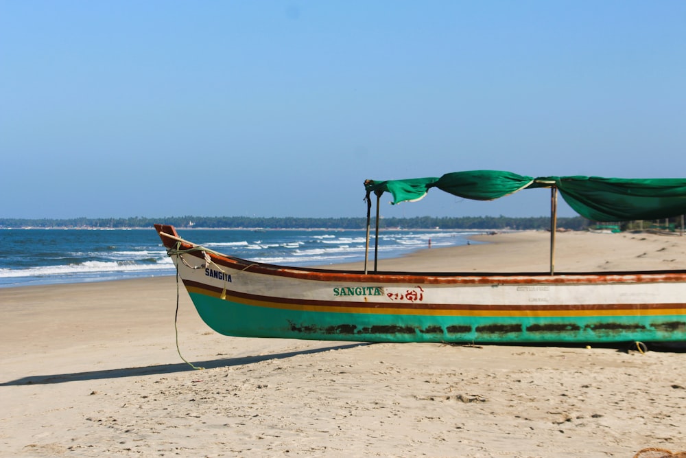 un bateau assis au sommet d’une plage de sable