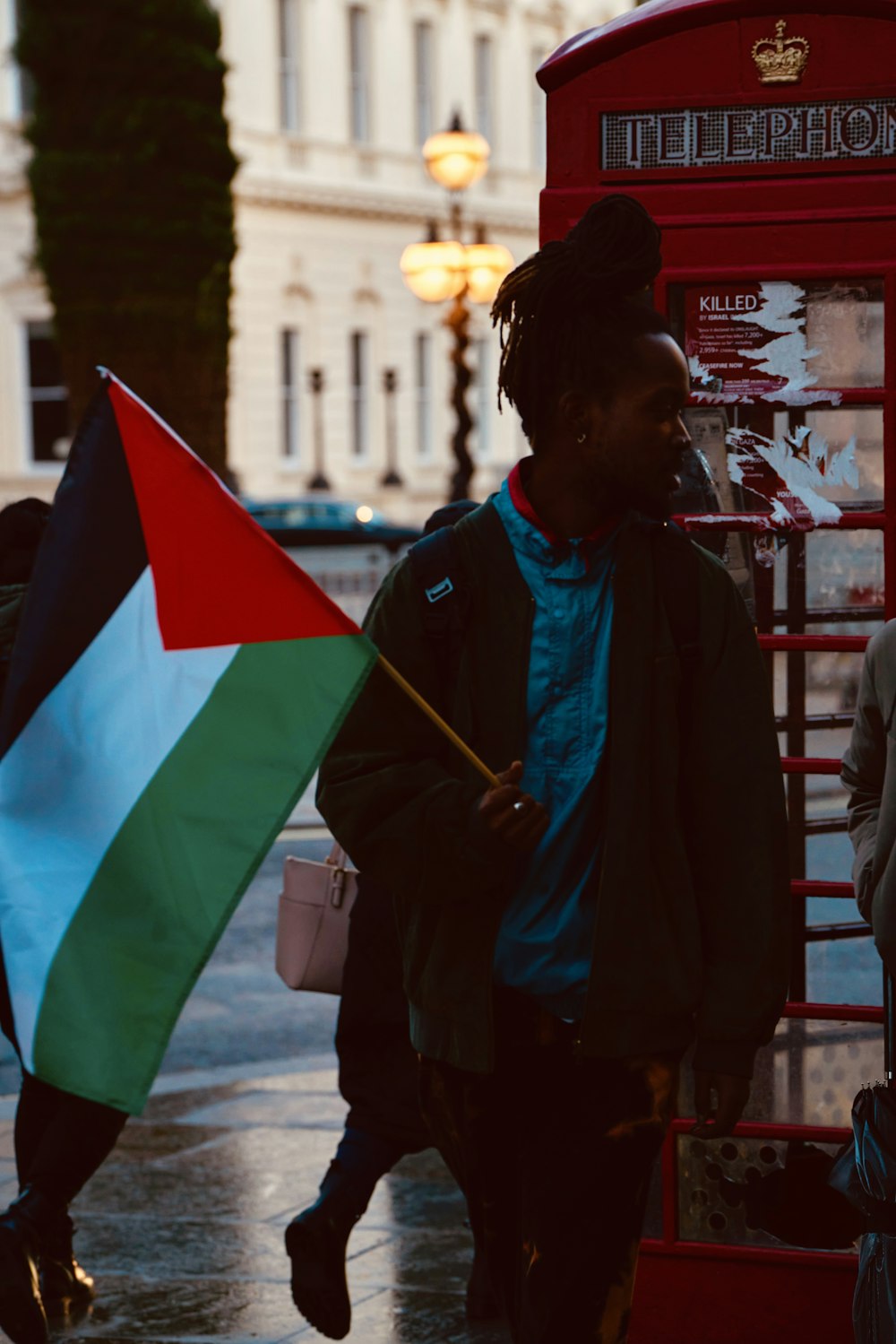 a man walking down a street holding a flag