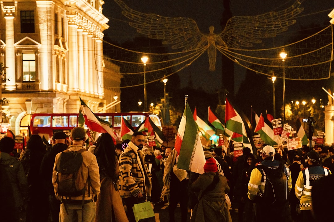 a large group of people holding flags in the street, An evening of protests in the streets of London in support of Pales