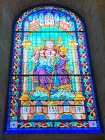 A vibrant stained glass window depicting a saint.