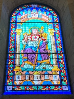 A vibrant stained glass window depicting a saint.