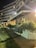 A multi-story building with illuminated windows at night, featuring a modern architectural design. Lush greenery and potted plants line the walkway leading to the entrance, with well-maintained lawns and foliage providing a serene atmosphere. Soft lighting enhances the ambiance, creating a welcoming environment.