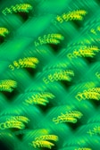 Blurred and overlapping green and yellow alphanumeric characters create an abstract and dynamic pattern. The text is illegible due to motion blur, presenting a sense of movement or digital flow.