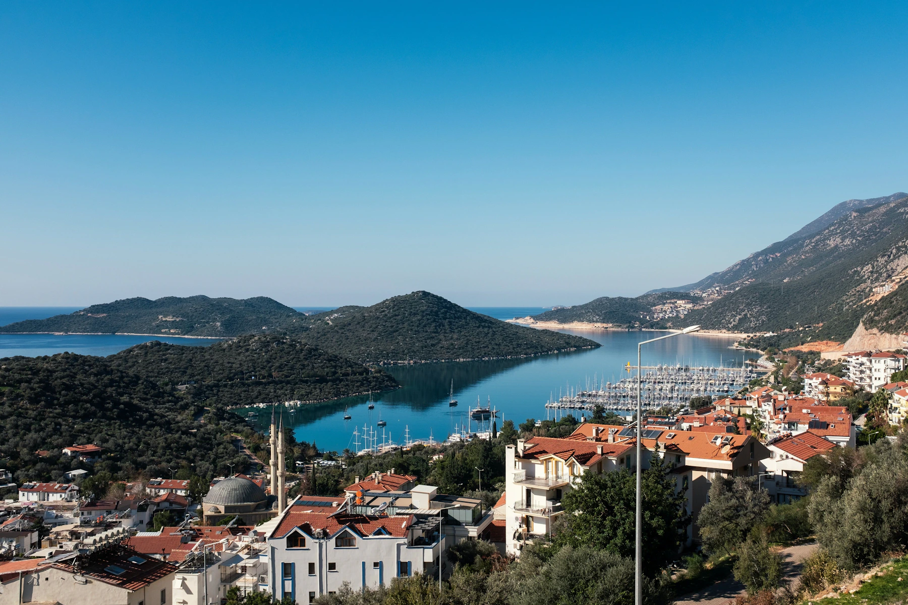 Aerial view of the turquoise Mediterranean harbor and red-roofed town of Kas, Turkey