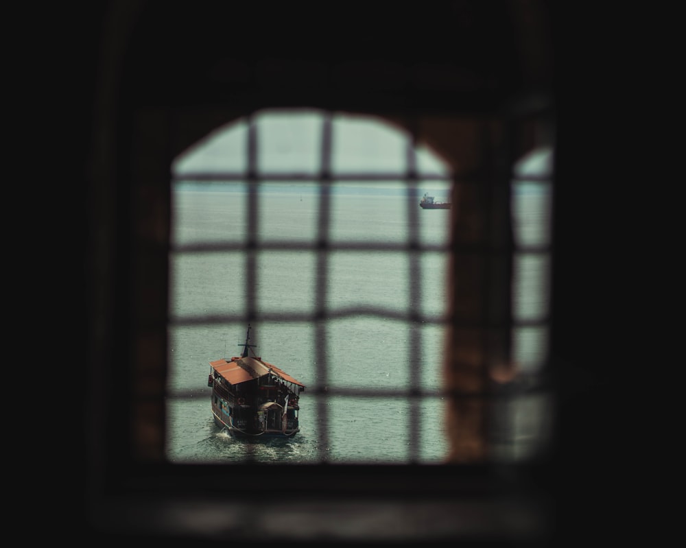 a boat in the water seen through a window