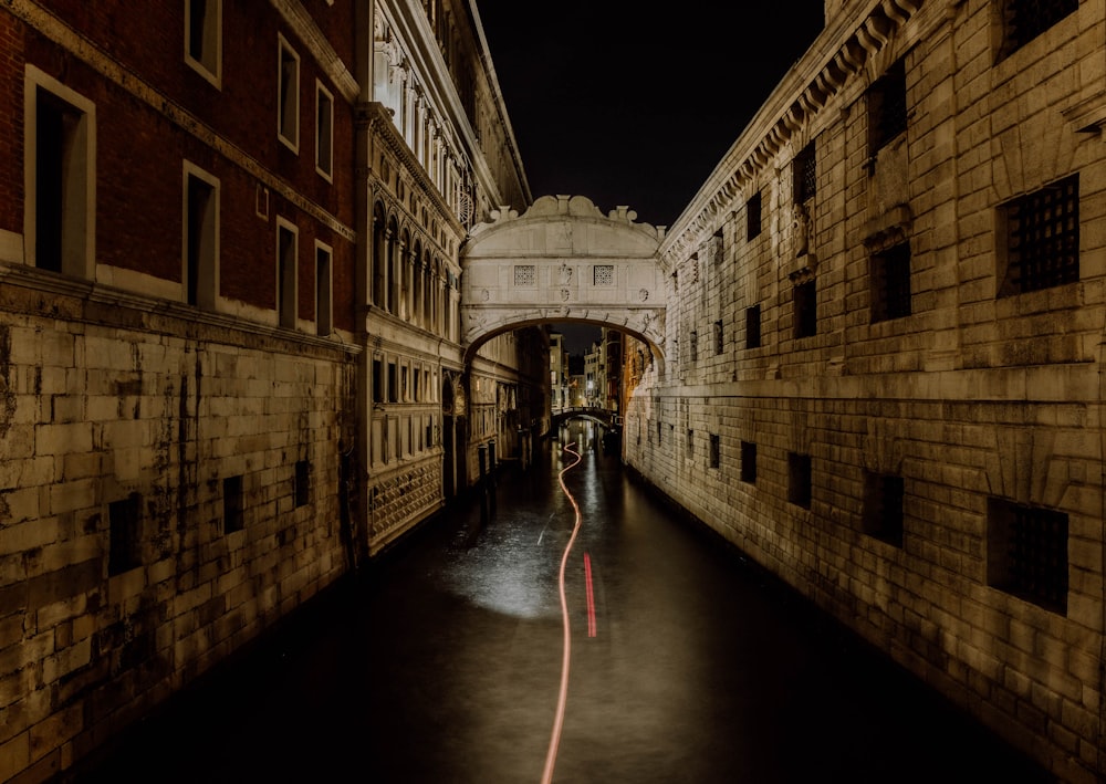 a narrow street with a bridge in the middle of it