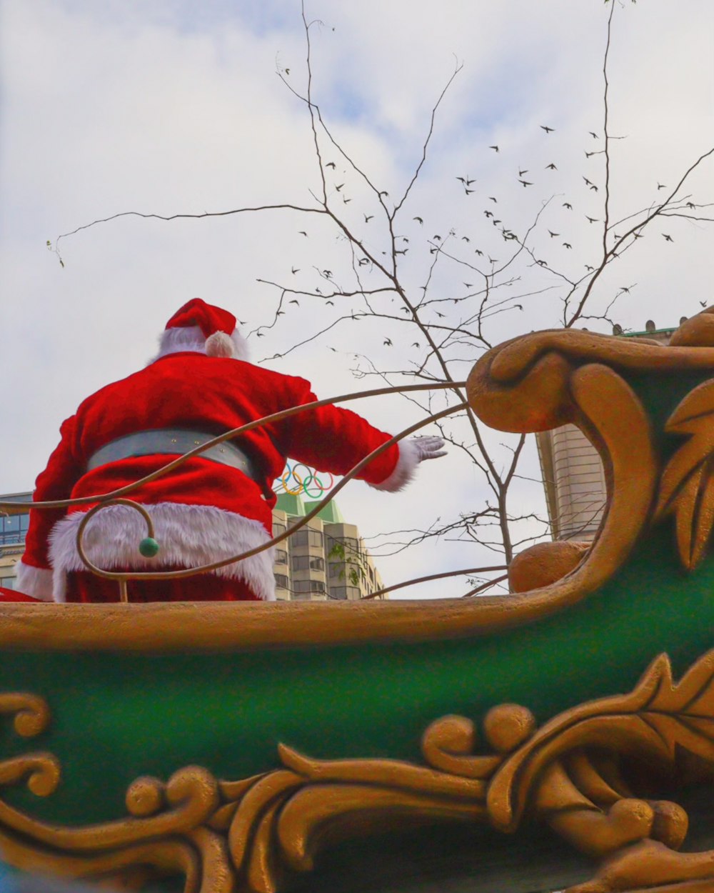 a santa clause in a green and gold sleigh