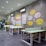 A modern coworking space with desks and chairs arranged for a meeting.