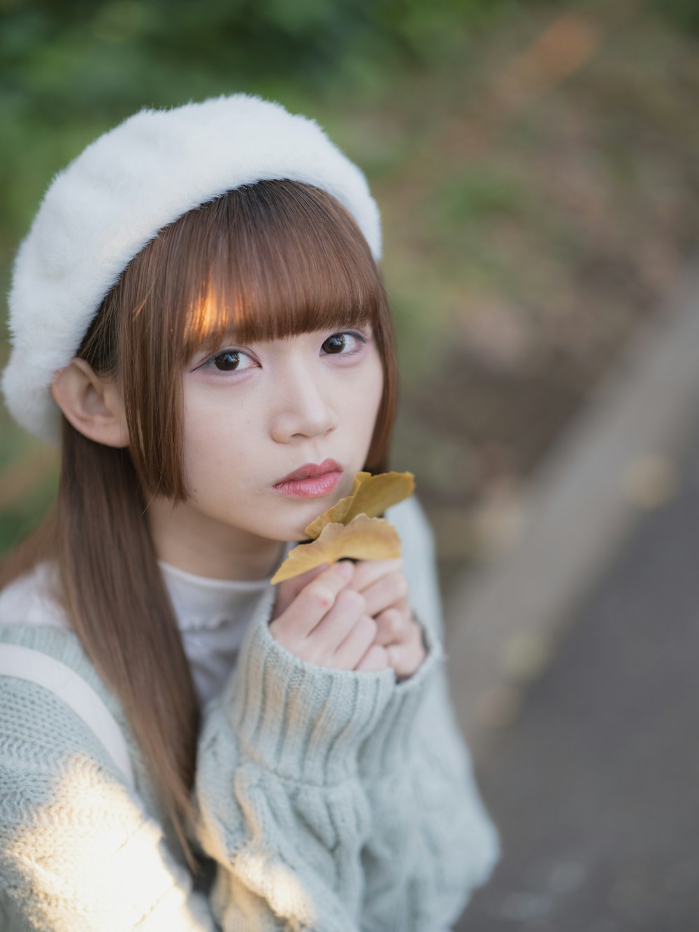 a woman in a white hat is eating a piece of food