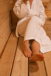 a woman sitting on a wooden bench in a sauna