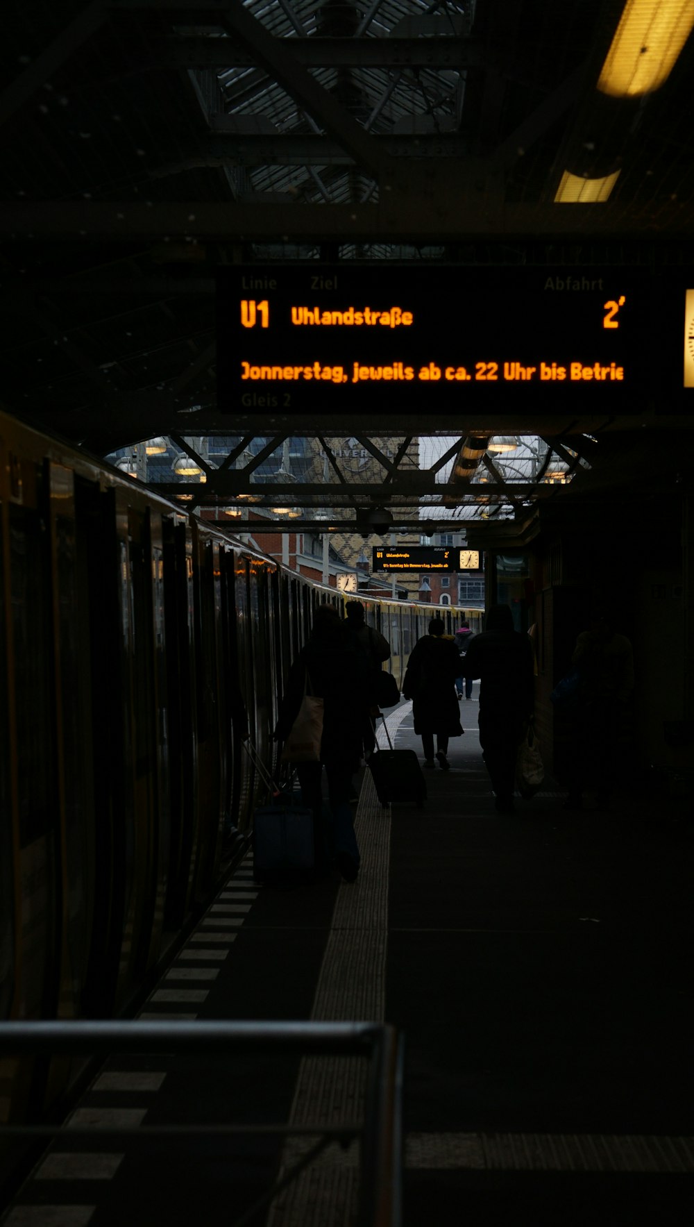 a group of people standing next to a train at a train station