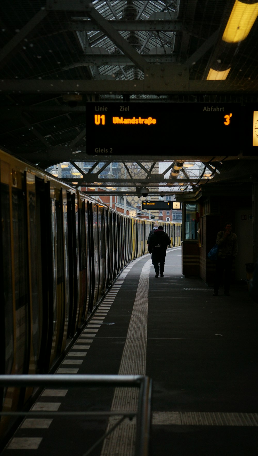 a train station with a person walking on the platform