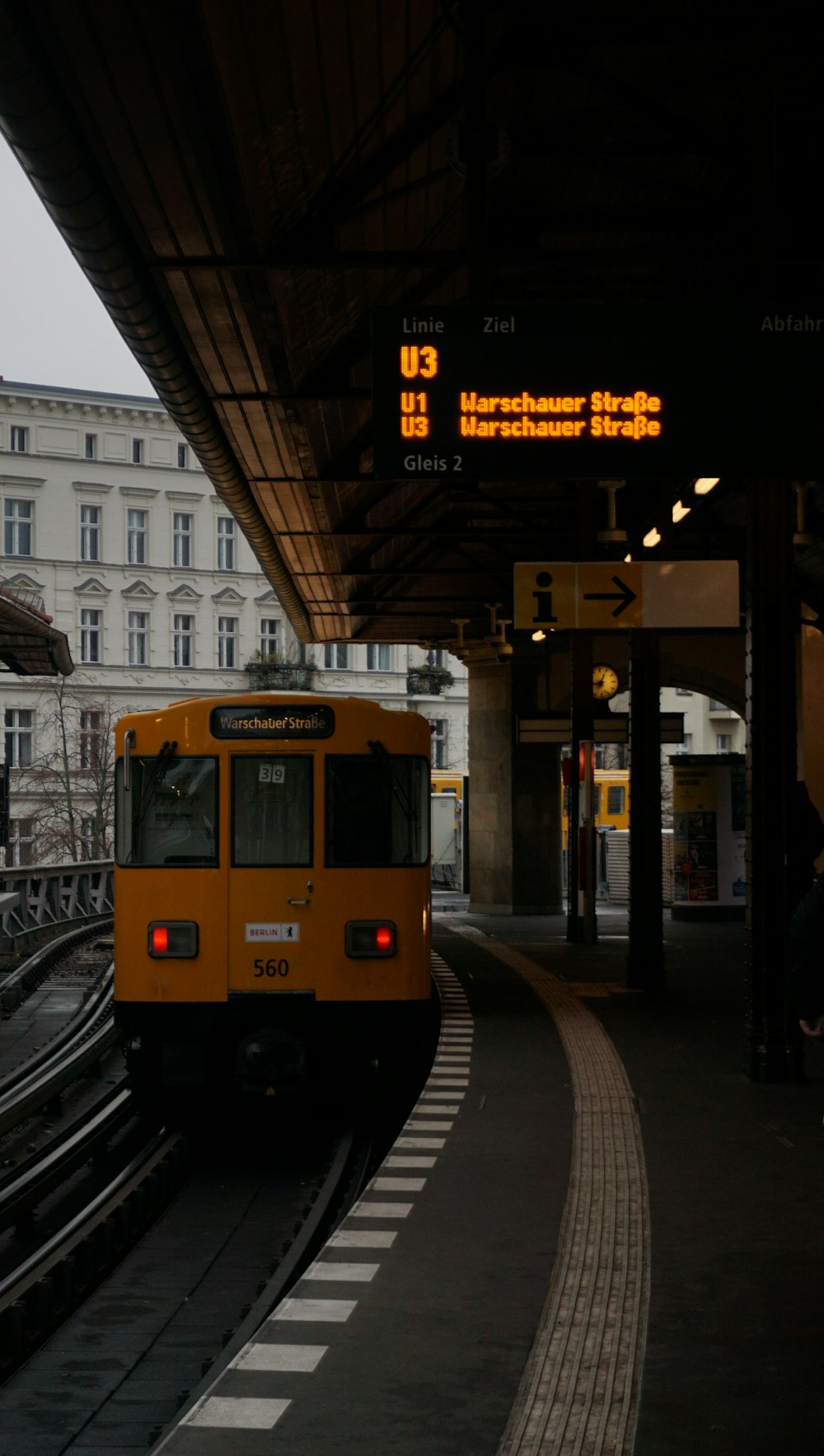 a yellow train pulling into a train station