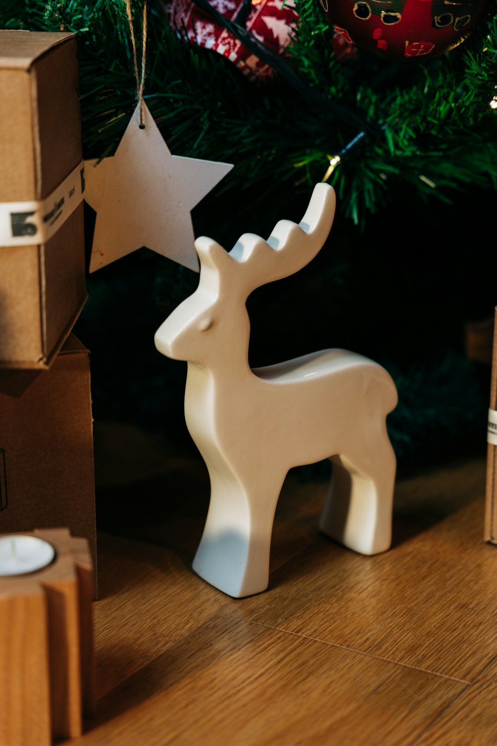 a white deer ornament next to a christmas tree