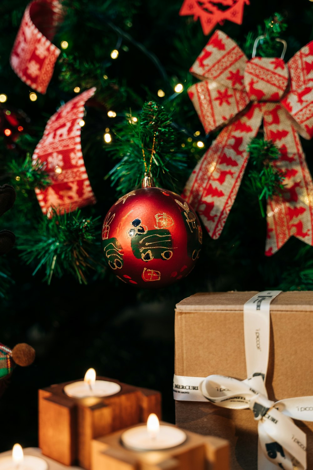 a christmas tree with candles and presents under it