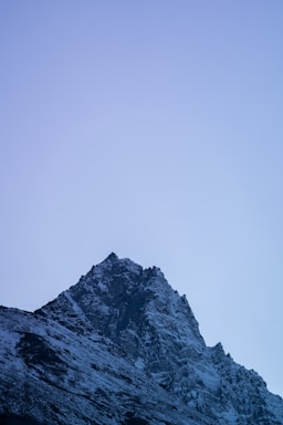 A sleek, icy mountain peak under a clear blue sky, symbolizing nortiq's cold, northern inspiration.