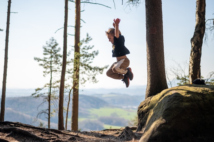 a person jumping in the air near some trees