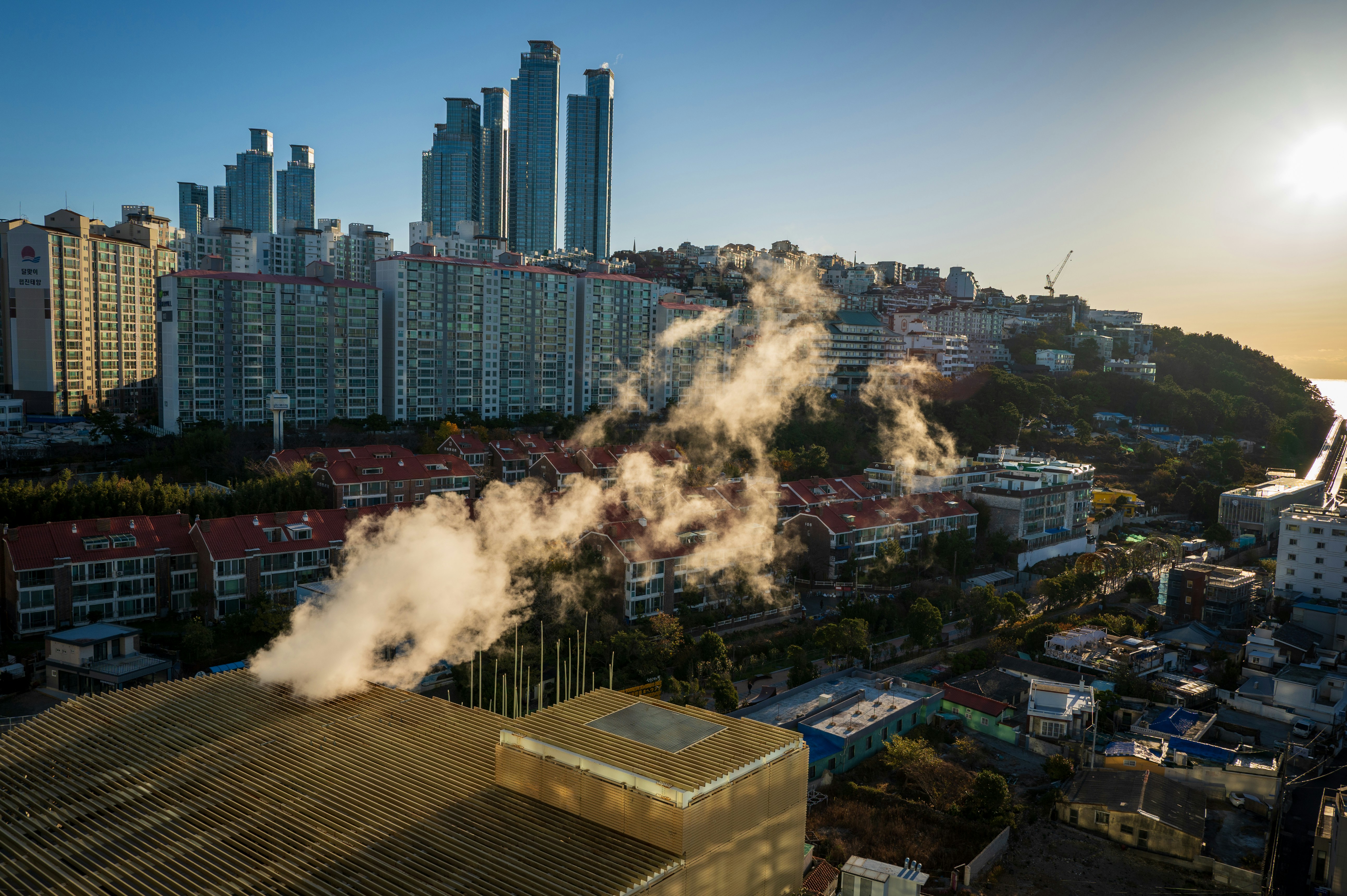 steam rises from the roof of a building in a city