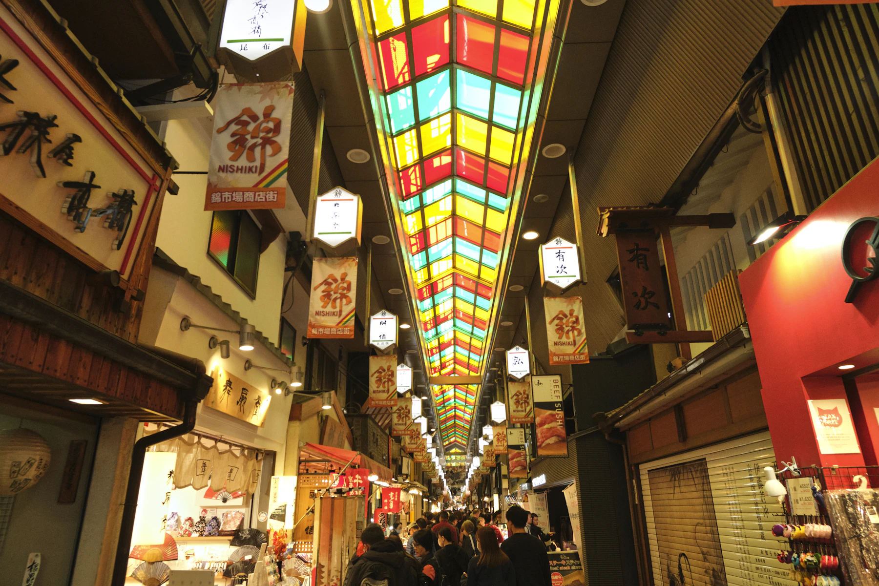 Überdachter Nishiki-Markt in Kyoto mit farbigem Glasdach und Geschäften
