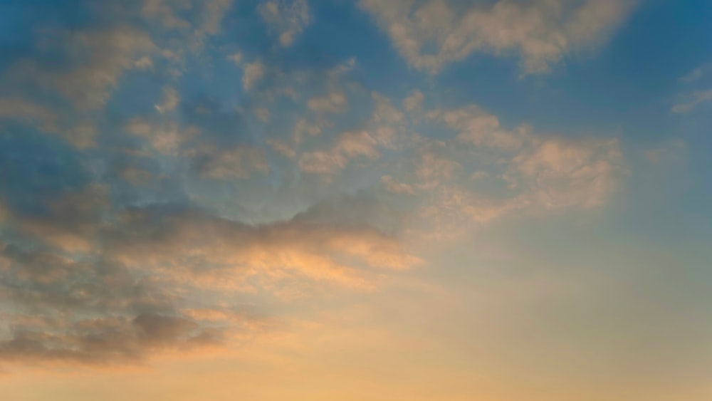 a group of people standing on top of a beach under a cloudy sky