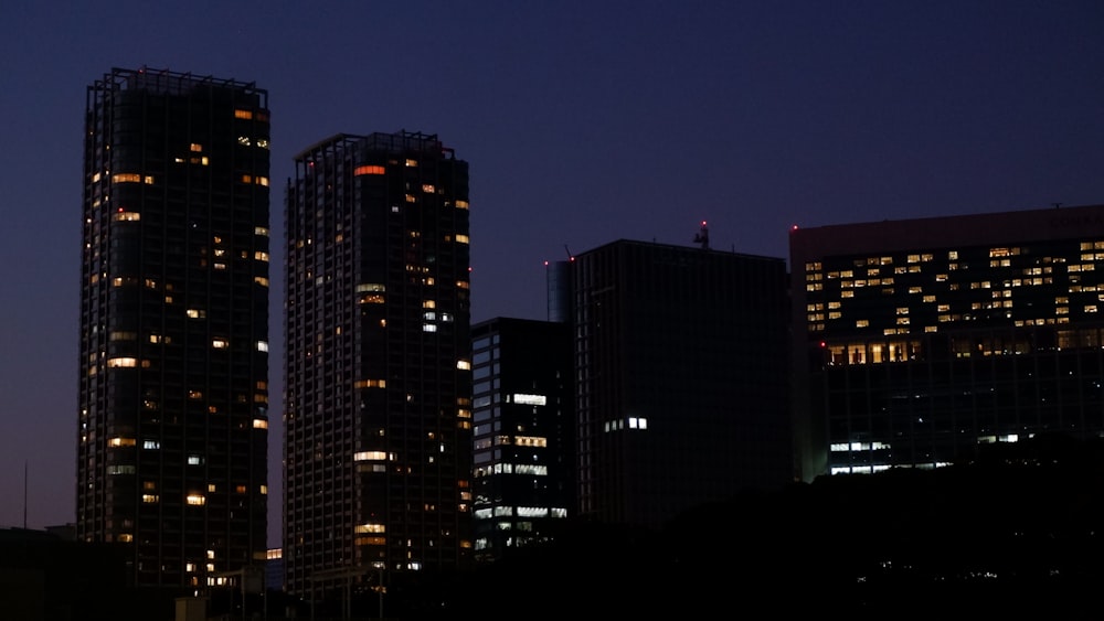 a group of tall buildings lit up at night
