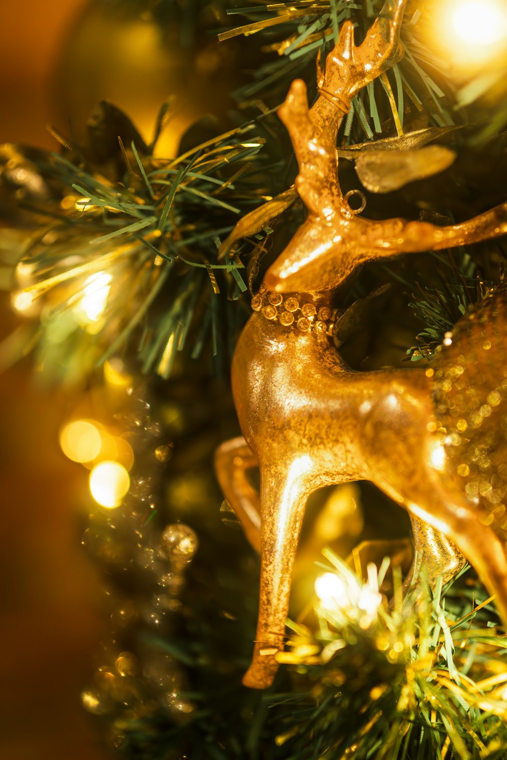 a gold deer ornament hanging from a christmas tree