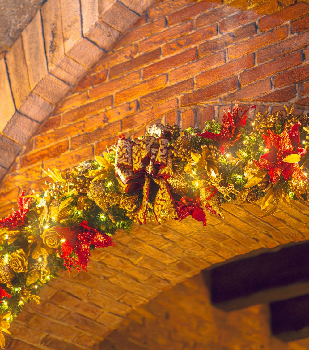 a christmas garland is hanging on a brick wall