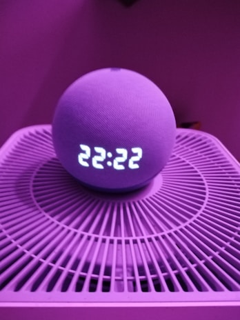 Close-up of a sleek smart home device with glowing LED indicators in a modern living room.