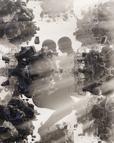 Abstract human figures are intertwined with complex, dark, geometric shapes and structures. There is a play of light and shadow, giving a sense of depth and texture. The overall composition has a surreal and futuristic appearance.