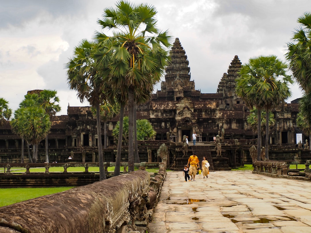 a group of people walking across a stone walkway,