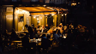 a group of people sitting at tables outside of a building