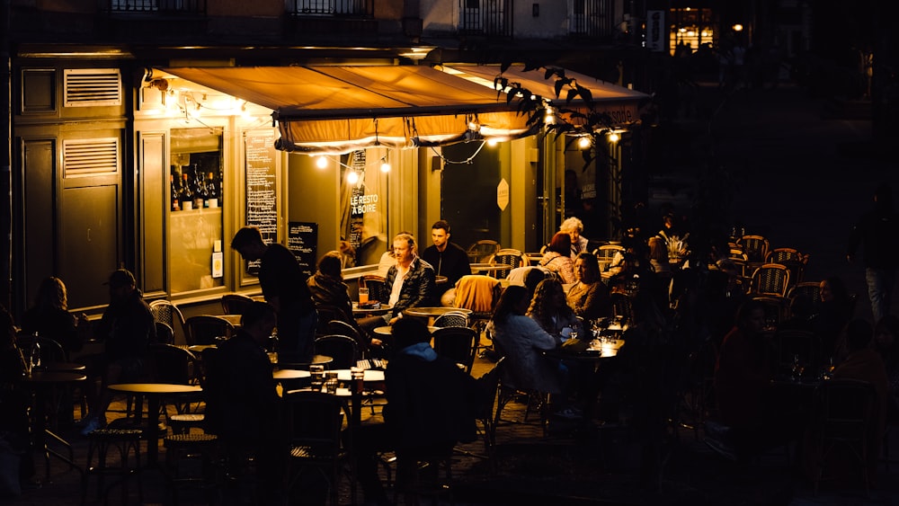 a group of people sitting at tables outside of a building