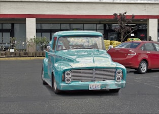 A turquoise and silver delivery truck parked outside the a & f logistics Altona office.