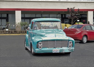A turquoise and silver delivery truck parked outside a warehouse in Altona.