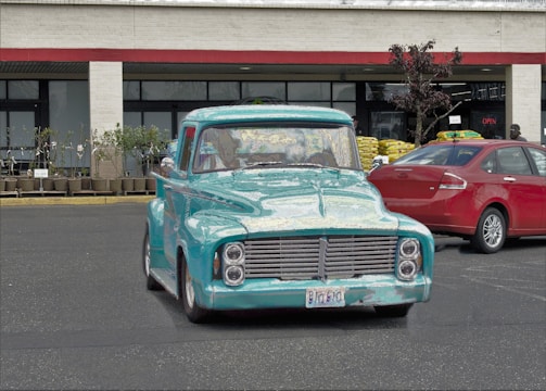 A turquoise and silver delivery truck parked outside a warehouse in Altona.