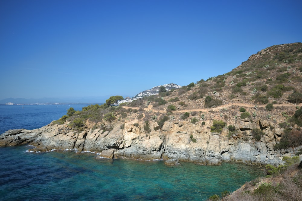 a rocky shore with clear blue water