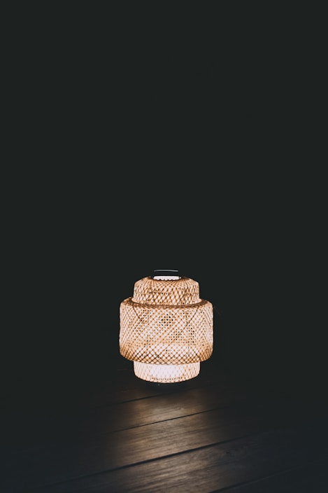 Close-up of a bamboo wall lantern showcasing its delicate weaving and natural texture against a calming wall.
