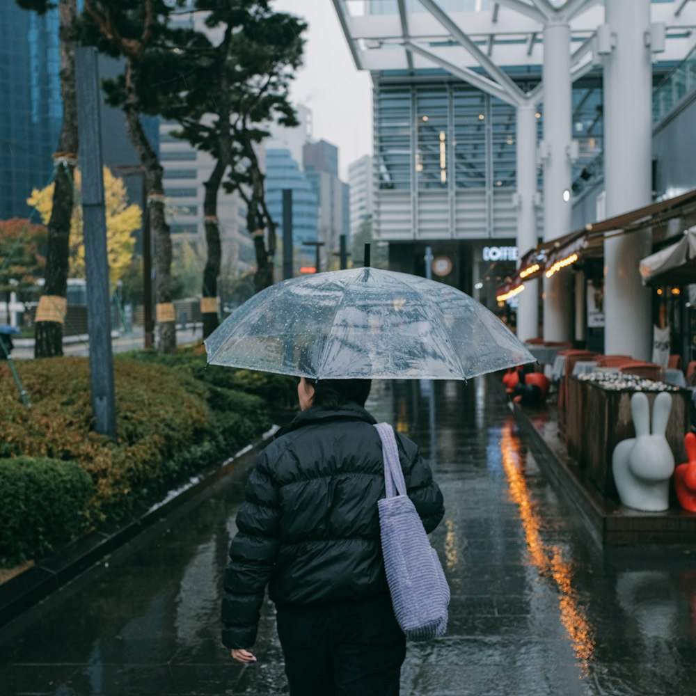 une personne marchant dans une rue tenant un parapluie