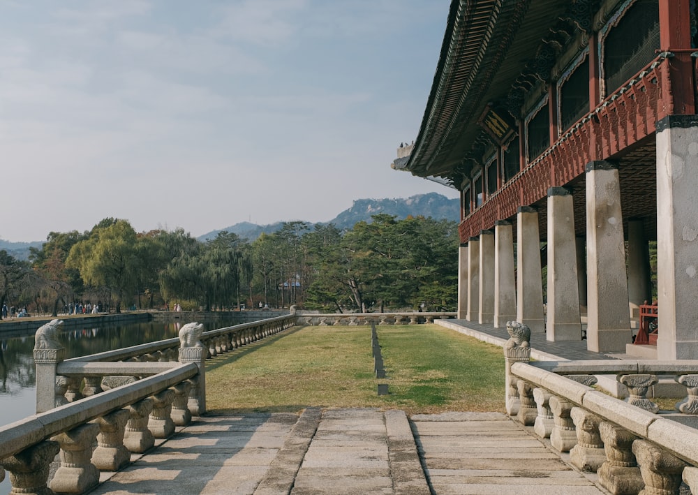 a walkway leading to a building next to a body of water