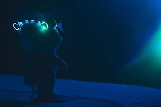 Futuristic humanoid figure glowing with neon red and white lights against a dark cyberpunk background.