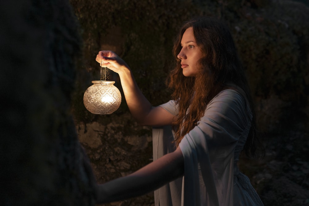 une femme tenant une lumière dans sa main