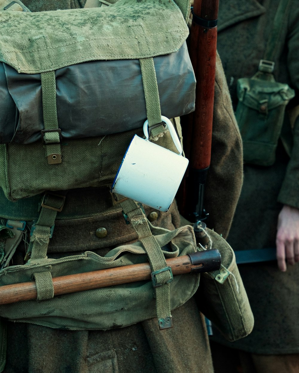 a man with a backpack and a cup in his hand