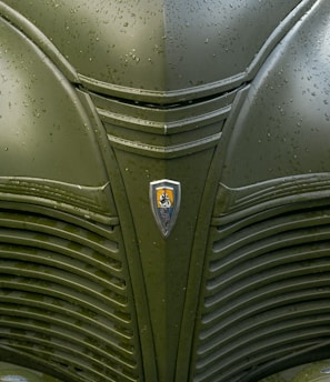 a close up of a green car with a badge on it