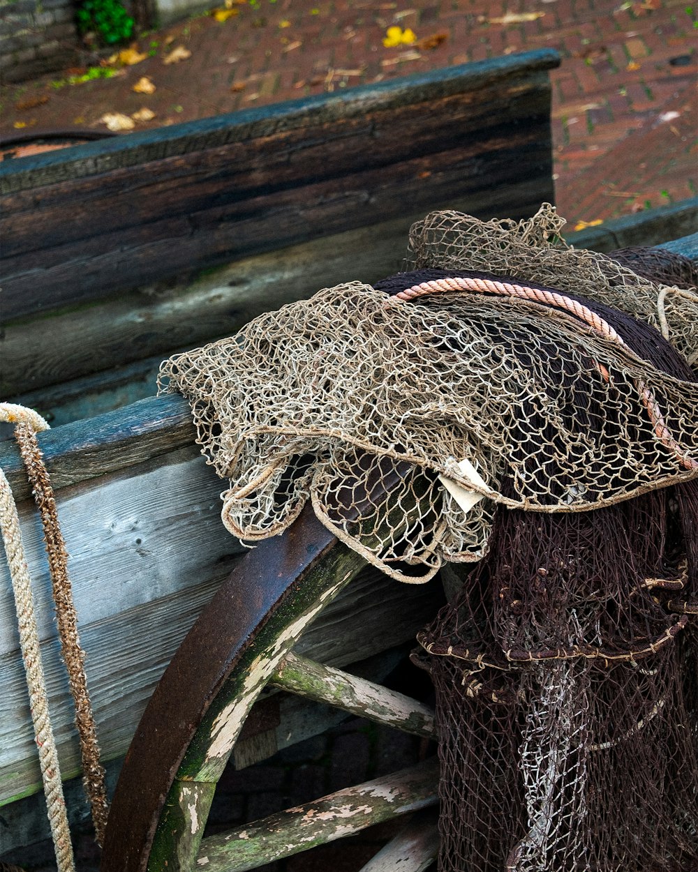 a pile of fishing nets sitting on top of a wooden bench