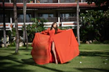 A model gracefully posing in a flowing orange ethnic dress against a soft neutral backdrop.