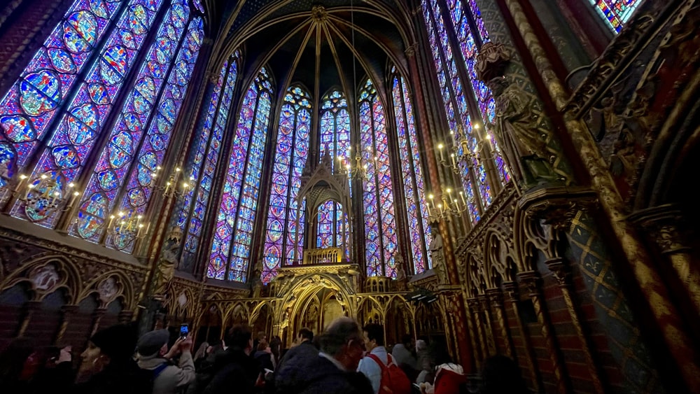 a group of people standing in front of a large stained glass window